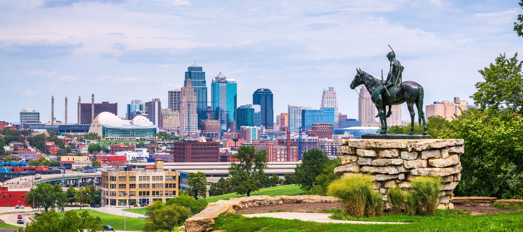 Kansas City, Missouri skyline featuring a bronze statue of a Native American on horseback overlooking the city